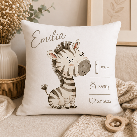 Cremefarbenes Baby-Kissen mit Zebra-Motiv, Namensfeld und Geburtsdaten, dekoriert mit Trockenblumen und einer Strickdecke