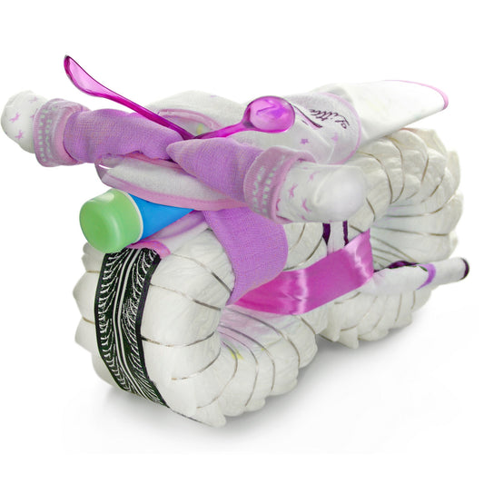 Pink ROCKSTAR diaper motorcycle made of diapers with baby socks, bib and care product on white