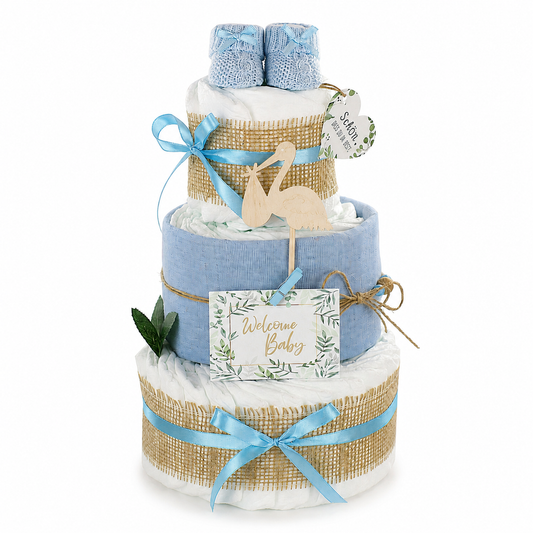 Blue diaper cake with baby booties, muslin cloth, wooden stork and “Welcome Baby” card on white