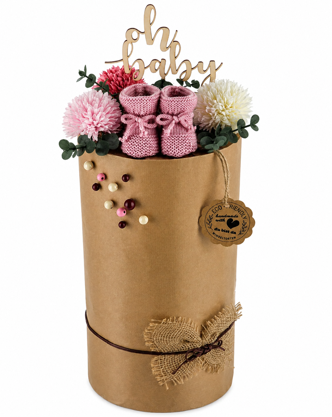Large kraft-paper diaper cake with pink booties, flowers, “Oh Baby” topper and rustic hessian bow