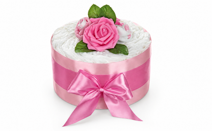 Rosa Windeltorte mit breiter Satinschleife, pinker Rosenblüte, Söckchenrosen und grünen Blättern auf Weiß