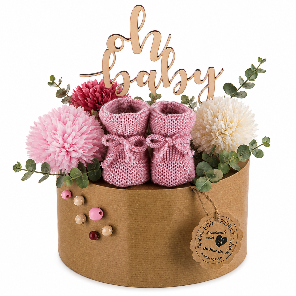 Nachhaltige Windeltorte Berry im Boho-Look mit Eukalyptus und Kraftpapier auf einem gedeckten Geschenktisch