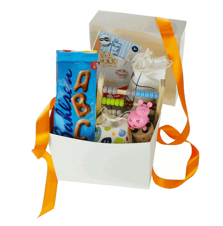 Bunte Geschenkbox zur Einschulung mit Holzspielzeug und Süßigkeiten, dekorativ verpackt