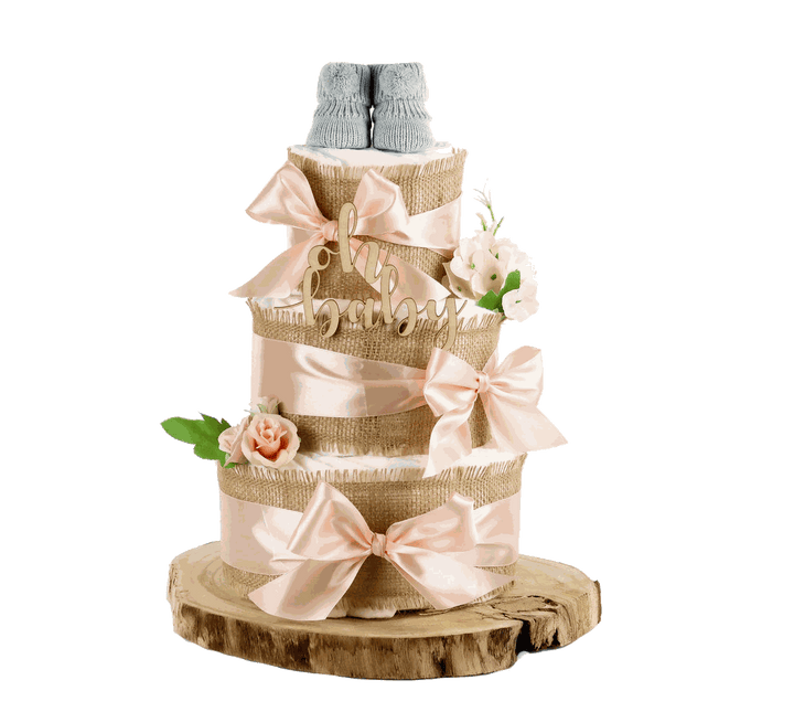 Große apricotfarbene Windeltorte mit drei Etagen, Jute, Schleifen, Blüten und grauen Babyschuhen auf Holzscheibe