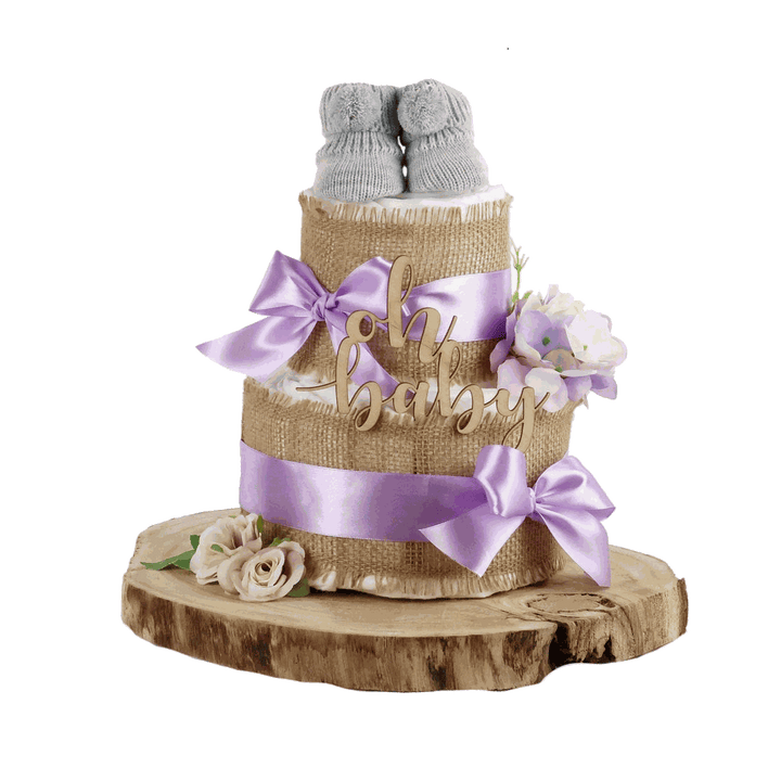 Windeltorte Alles Jute in Flieder mit grauen Babyschuhen, Holzschriftzug und Blumen auf einer Holzscheibe